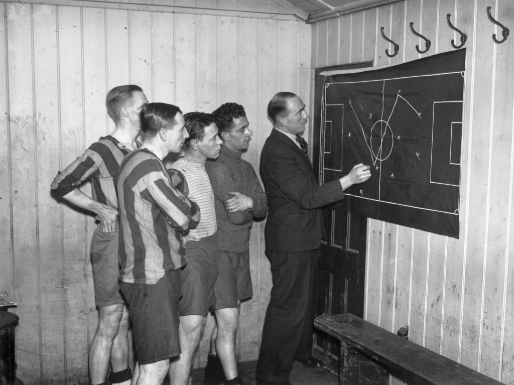 9th January 1933: Former Arsenal Captain, Tom Parker demonstrating positional play to members of the Nunhead team in the changing room. (Photo by J. A. Hampton/Topical Press Agency/Getty Images)