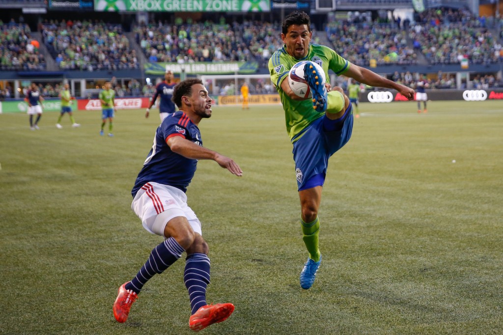 SEATTLE, WA - MARCH 08: Leonardo Gonzalez #12 of the Seattle Sounders FC battles Kevin Alston #30 of the New England Revolution at CenturyLink Field on March 8, 2015 in Seattle, Washington. The Sounders defeated the Revolution 3-0. (Photo by Otto Greule Jr/Getty Images)