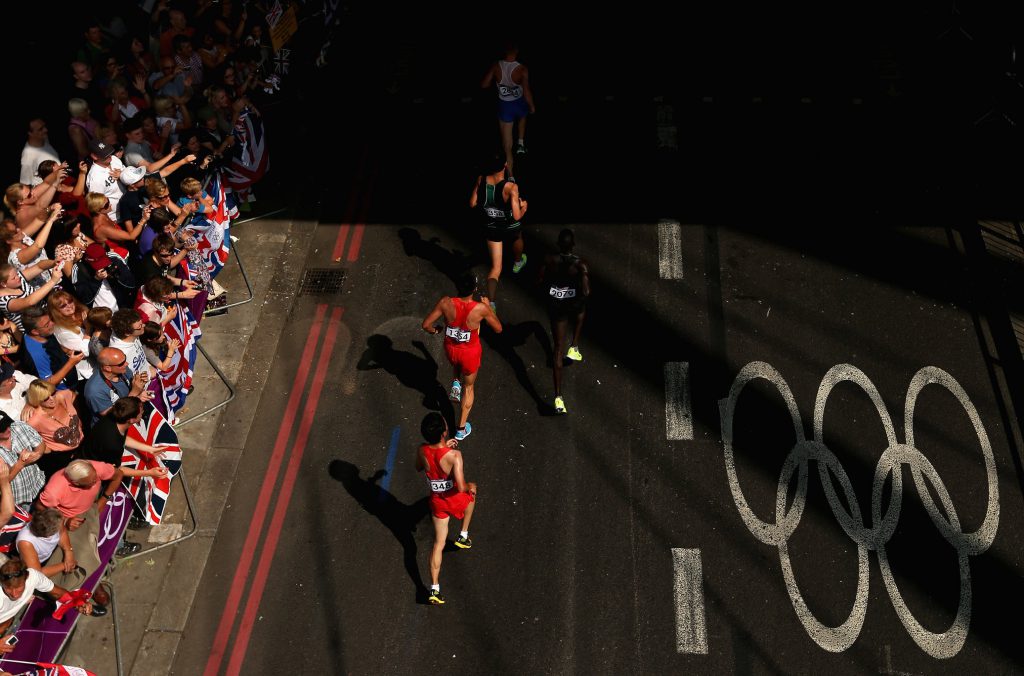 LONDON, ENGLAND - AUGUST 12: (From bottom) Guojian Dong of China, Zicheng Li of China, Guor Marial of Independent Olympic Athletes, Duhaeng Lee of Korea and Aleksey Reunkov of Russia are cheered along by spectators as they compete in the Men's Marathon on Day 16 of the London 2012 Olympic Games on the streets of London on August 12, 2012 in London, England. (Photo by Ezra Shaw/Getty Images)