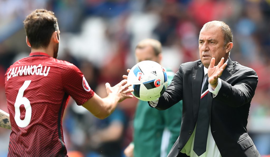 Turkey's coach Fatih Terim passes a ball to Turkey's midfielder Hakan Calhanoglu during the Euro 2016 group D football match between Turkey and Croatia at Parc des Princes in Paris on June 12, 2016. / AFP / BULENT KILIC (Photo credit should read BULENT KILIC/AFP/Getty Images)