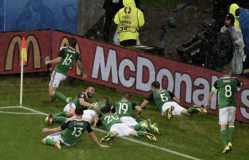 Northern Ireland's defender Gareth McAuley (3L) celebrates with teammates after scoring during the Euro 2016 group C football match between Ukraine and Northern Ireland at the Parc Olympique Lyonnais stadium in Décines-Charpieu near Lyon on June 16, 2016. / AFP / JEAN-PHILIPPE KSIAZEK (Photo credit should read JEAN-PHILIPPE KSIAZEK/AFP/Getty Images)