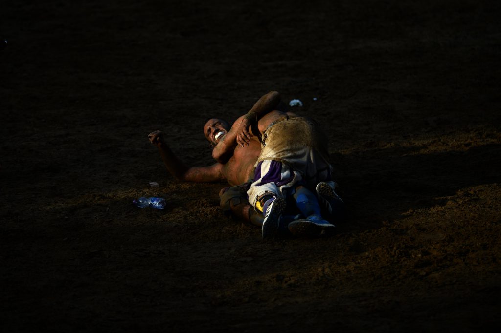 Calciante 'footkicker' of the white team clashes with calciante of the blue team during the final match of the calcio storico fiorentino traditional XVI century ball game in Florence Piazza Santa Croce on June 24, 2016. / AFP / FILIPPO MONTEFORTE (Photo credit should read FILIPPO MONTEFORTE/AFP/Getty Images)