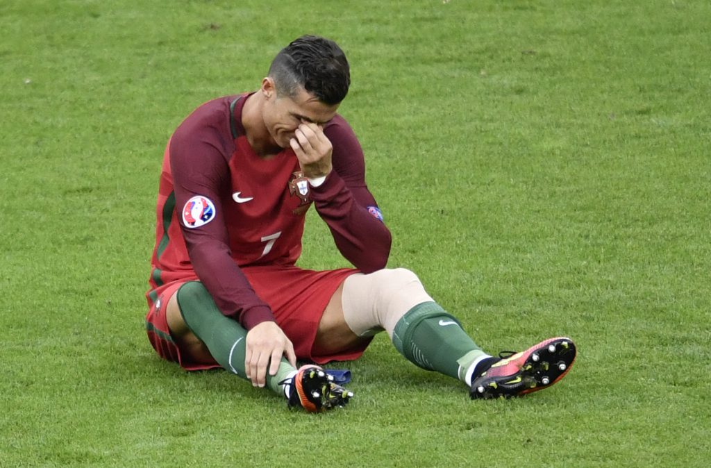 Portugal's forward Cristiano Ronaldo reacts after an injury during the Euro 2016 final football match between Portugal and France at the Stade de France in Saint-Denis, north of Paris, on July 10, 2016. / AFP / PHILIPPE LOPEZ (Photo credit should read PHILIPPE LOPEZ/AFP/Getty Images)