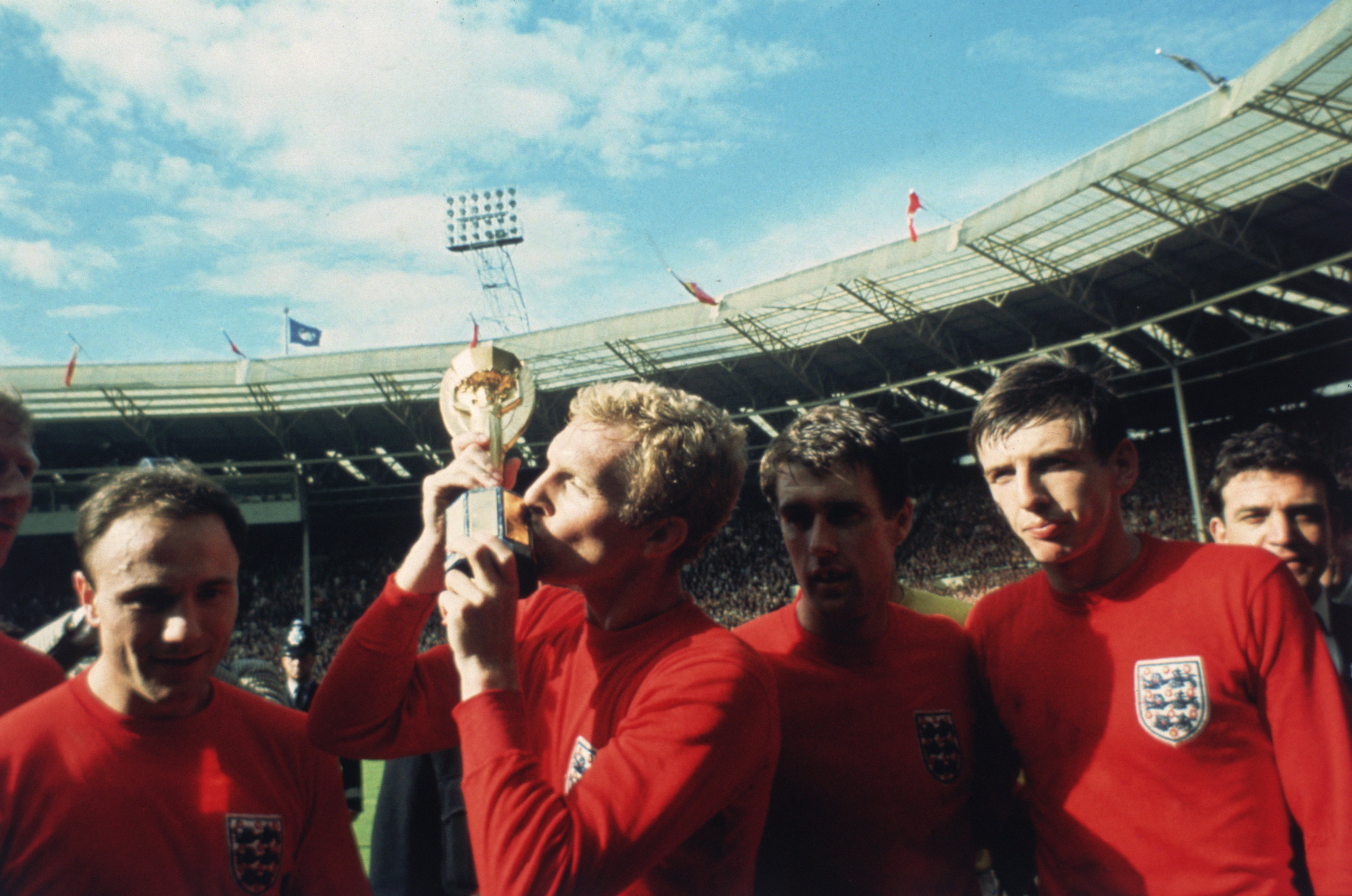 England captain Bobby Moore kissing the Jules Rimet trophy as the team celebrate winning the 1966 World Cup final against Germany at Wembley Stadium. His team mates are, left to right, George Cohen, Geoff Hurst and Martin Peters, 30th July 1966. (Photo by Hulton Archive/Getty Images)