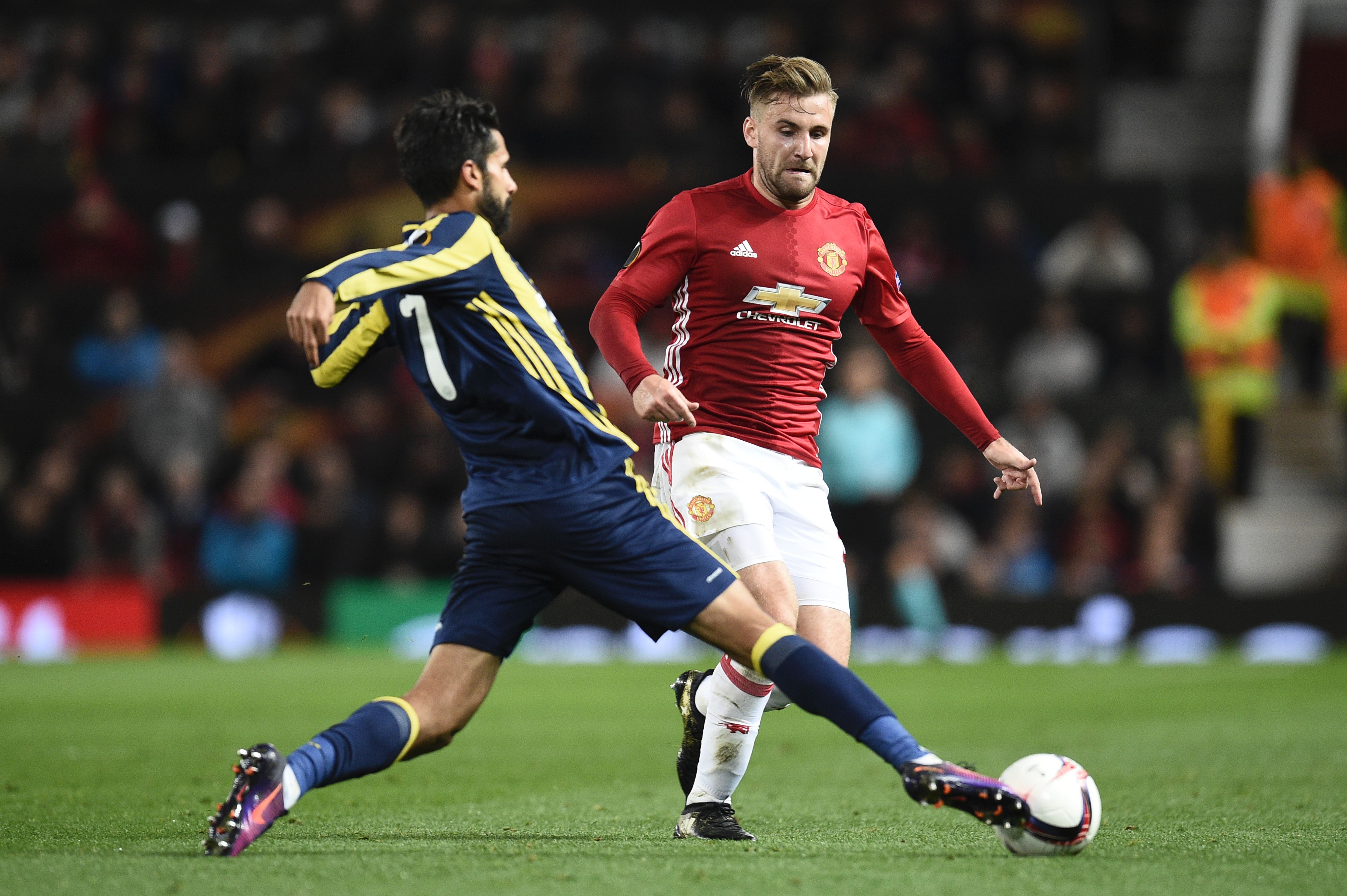 Manchester United's English defender Luke Shaw (R) challenges Fenerbahce's Turkish midfielder Alper Potuk (L) during the UEFA Europa League group A football match between Manchester United and Fenerbahce at Old Trafford in Manchester, north west England, on October 20, 2016. / AFP / OLI SCARFF (Photo credit should read OLI SCARFF/AFP/Getty Images)