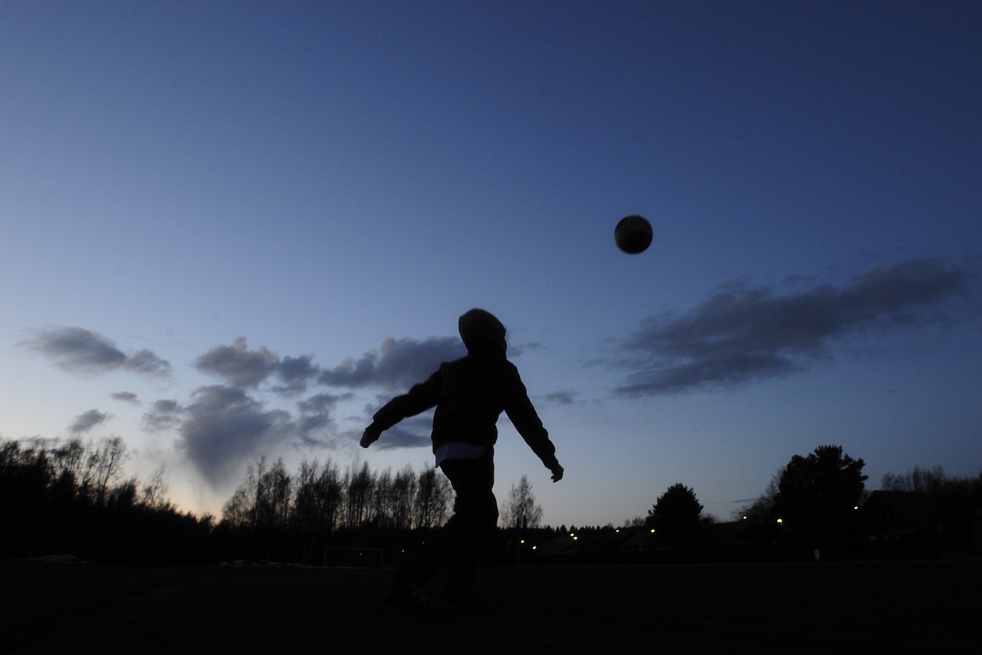 A child plays with a ball in front of a dark grey cloud with fallout, north of Vaasa at sunset, in clear skies, on April 16, 2010. Iceland's second volcano eruption in less than a month has sent plumes of ash and smoke billowing more than 20,000 feet (6,000 metres) into the sky. The massive ash cloud is gradually sweeping across Europe and forcing the continent's biggest air travel shutdown since World War II. AFP PHOTO/OLIVIER MORIN (Photo credit should read OLIVIER MORIN/AFP/Getty Images)