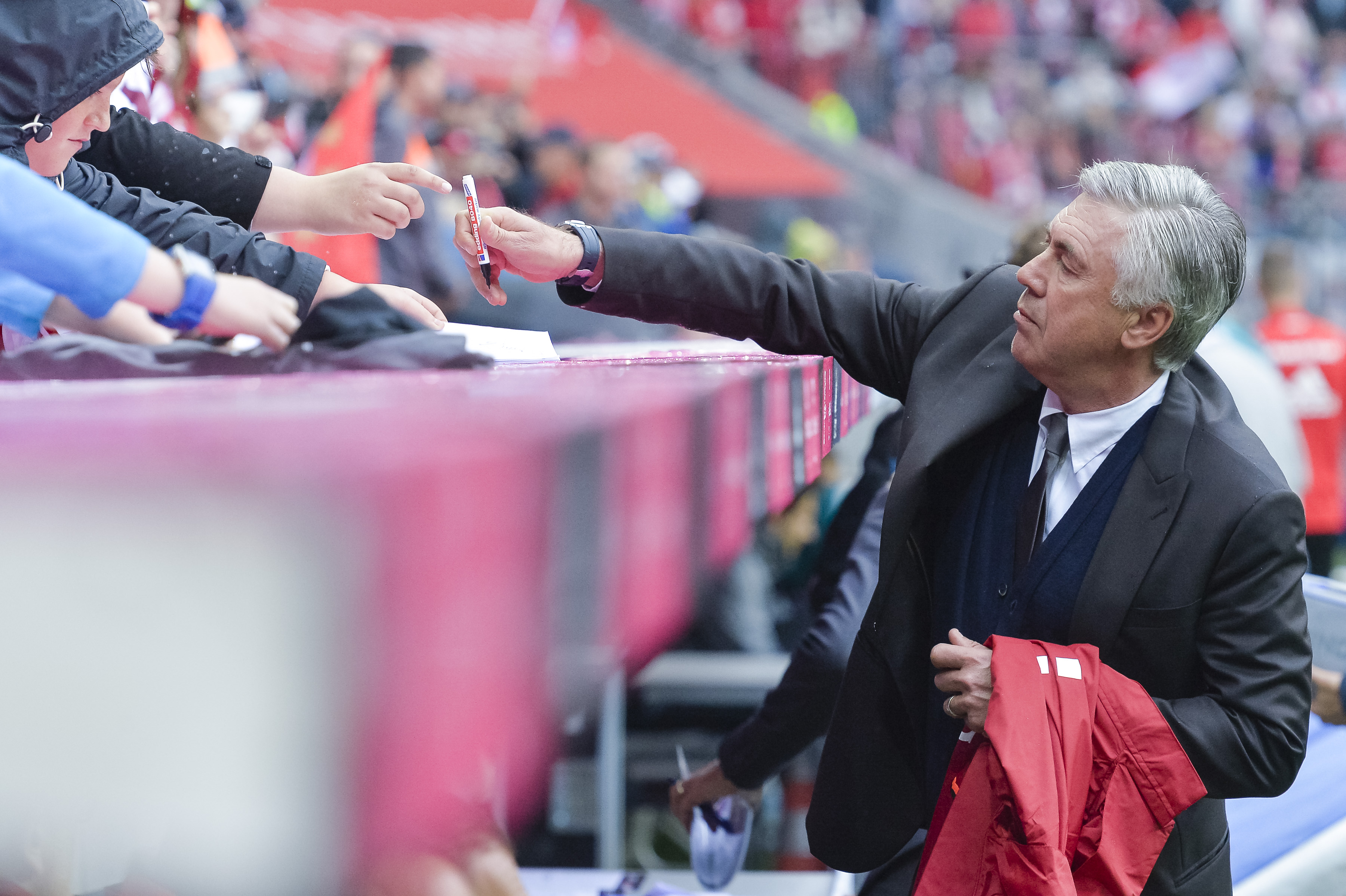 Bayern Munich's Italian head coach Carlo Ancelotti gives autographes during the German first division Bundesliga football match of Bayern Munich vs FC Ingolstadt in Munich, southern Germany, on September 17, 2016. / AFP / GUENTER SCHIFFMANN / RESTRICTIONS: DURING MATCH TIME: DFL RULES TO LIMIT THE ONLINE USAGE TO 15 PICTURES PER MATCH AND FORBID IMAGE SEQUENCES TO SIMULATE VIDEO. == RESTRICTED TO EDITORIAL USE == FOR FURTHER QUERIES PLEASE CONTACT DFL DIRECTLY AT + 49 69 650050 (Photo credit should read GUENTER SCHIFFMANN/AFP/Getty Images)