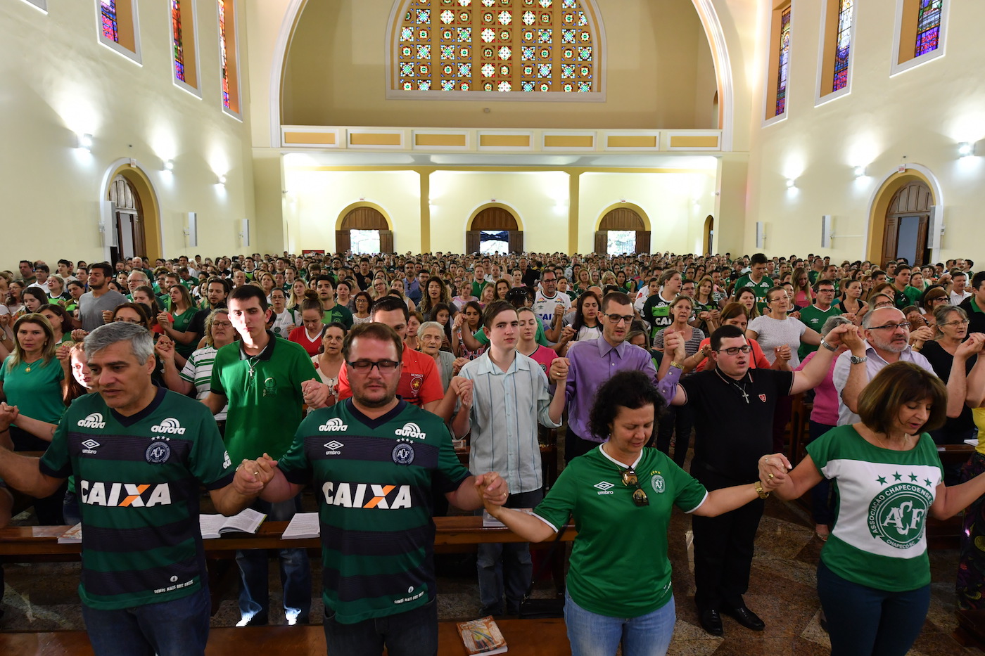 People attend a mass in memoriam of the players of Brazilian team Chapecoense Real killed in a plane crash in the Colombian mountains, in Chapeco, in the southern Brazilian state of Santa Catarina, on November 29, 2016. Players of the Chapecoense were among 81 people on board the doomed flight that crashed into mountains in northwestern Colombia, in which officials said just six people were thought to have survived, including three of the players. Chapecoense had risen from obscurity to make it to the Copa Sudamericana finals scheduled for Wednesday against Atletico Nacional of Colombia. / AFP / Nelson Almeida (Photo credit should read NELSON ALMEIDA/AFP/Getty Images)