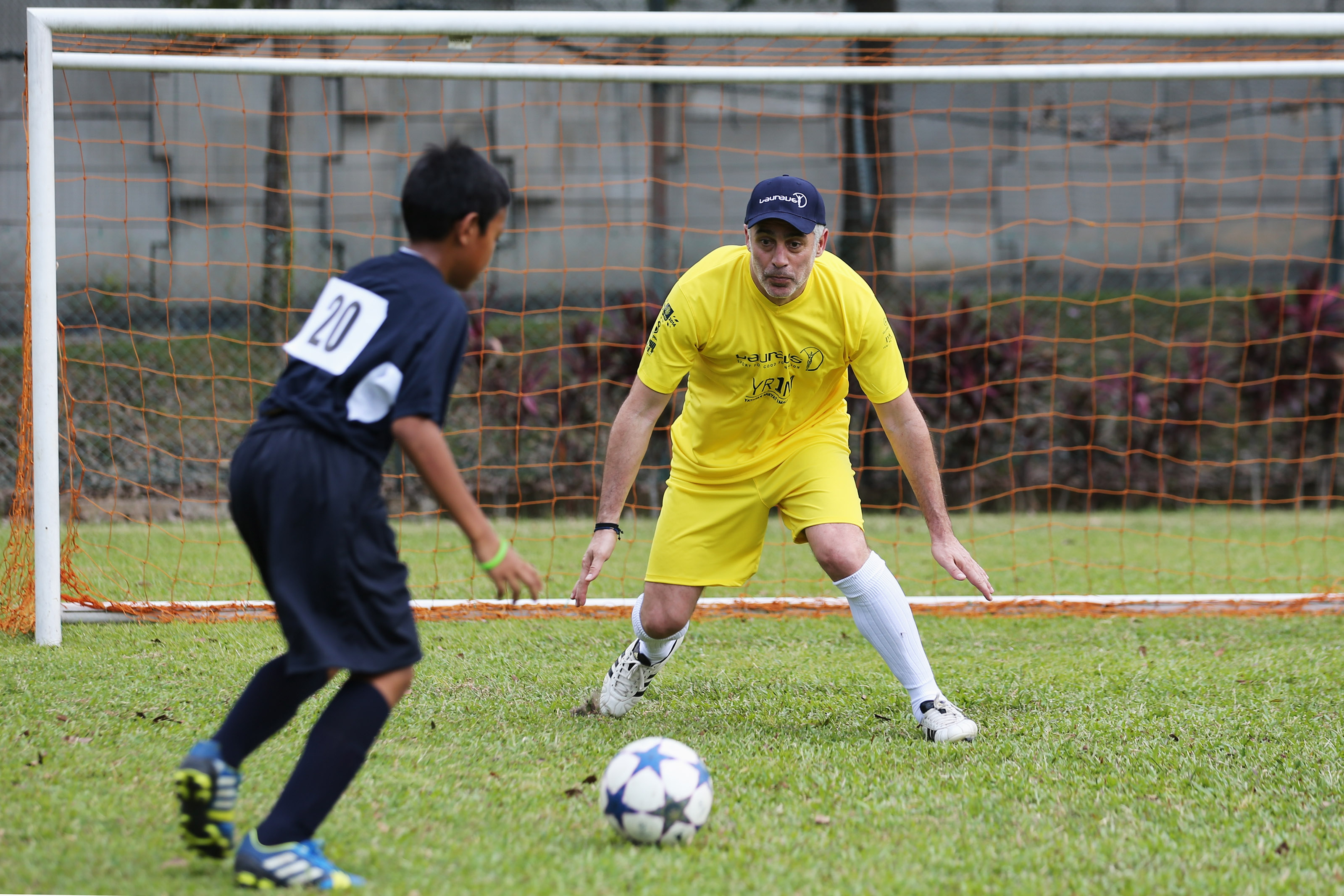 KUALA LUMPUR, MALAYSIA - MARCH 25: Antonios Nikopolidis faces a young player in a shooting session during the Laureus All Stars Unity Cup ahead of the 2014 Laureus World Sports Awards at Royal Selangor Club on March 25, 2014 in Kuala Lumpur, Malaysia. (Photo by Ian Walton/Getty Images for Laureus)