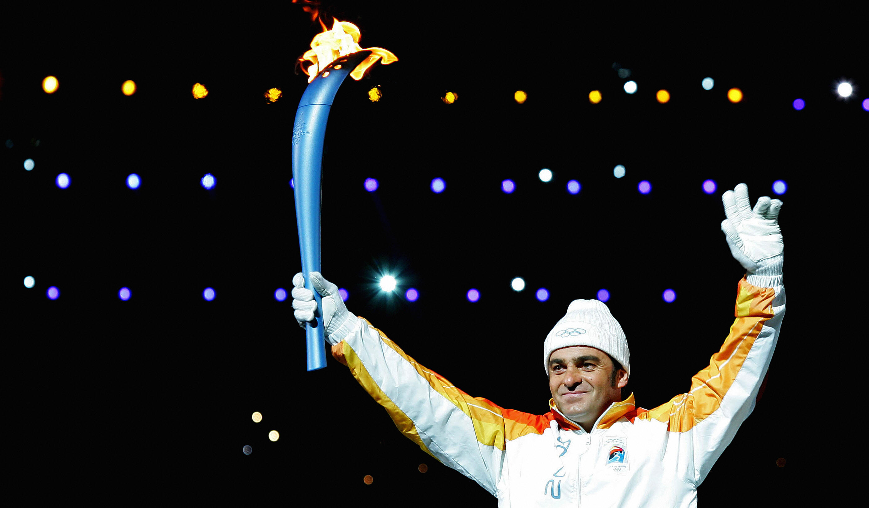 Turin, ITALY:  Italian skiing legend Alberto Tomba holds the Olympic flame during the opening ceremony of the 2006 Winter Olympics at the Olympic stadium in Turin, 10 February 2006.  Hosts Turin welcomed their first Winter Olympics in 50 years with a star-studded Opening Ceremony to inaugurate the 20th Winter Games.   AFP PHOTO/FRANCK FIFE  (Photo credit should read FRANCK FIFE/AFP/Getty Images)