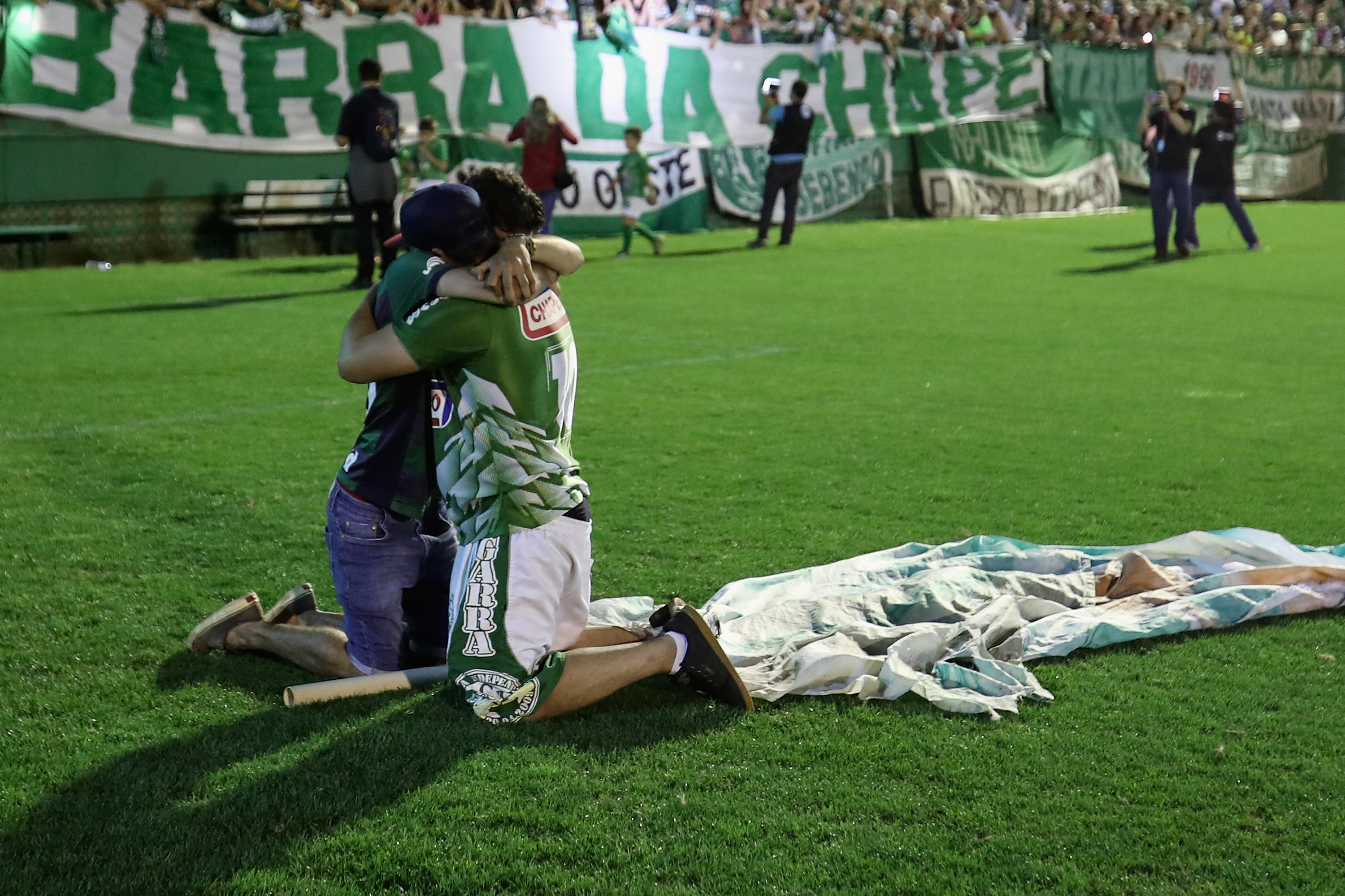 CHAPECO, BRAZIL - NOVEMBER 30: Fans cry while paying tribute to the players of Brazilian team Chapecoense Real at the club's Arena Conda stadium in Chapeco, in the southern Brazilian state of Santa Catarina, on November 30, 2016. The players were killed in a plane accident in the Colombian mountains. Players of the Chapecoense team were among the 77 people on board the doomed flight that crashed into mountains in northwestern Colombia. Officials said just six people were thought to have survived, including three of the players. Chapecoense had risen from obscurity to make it to the Copa Sudamericana finals scheduled for Wednesday against Atletico Nacional of Colombia. (Photo by Buda Mendes/Getty Images)