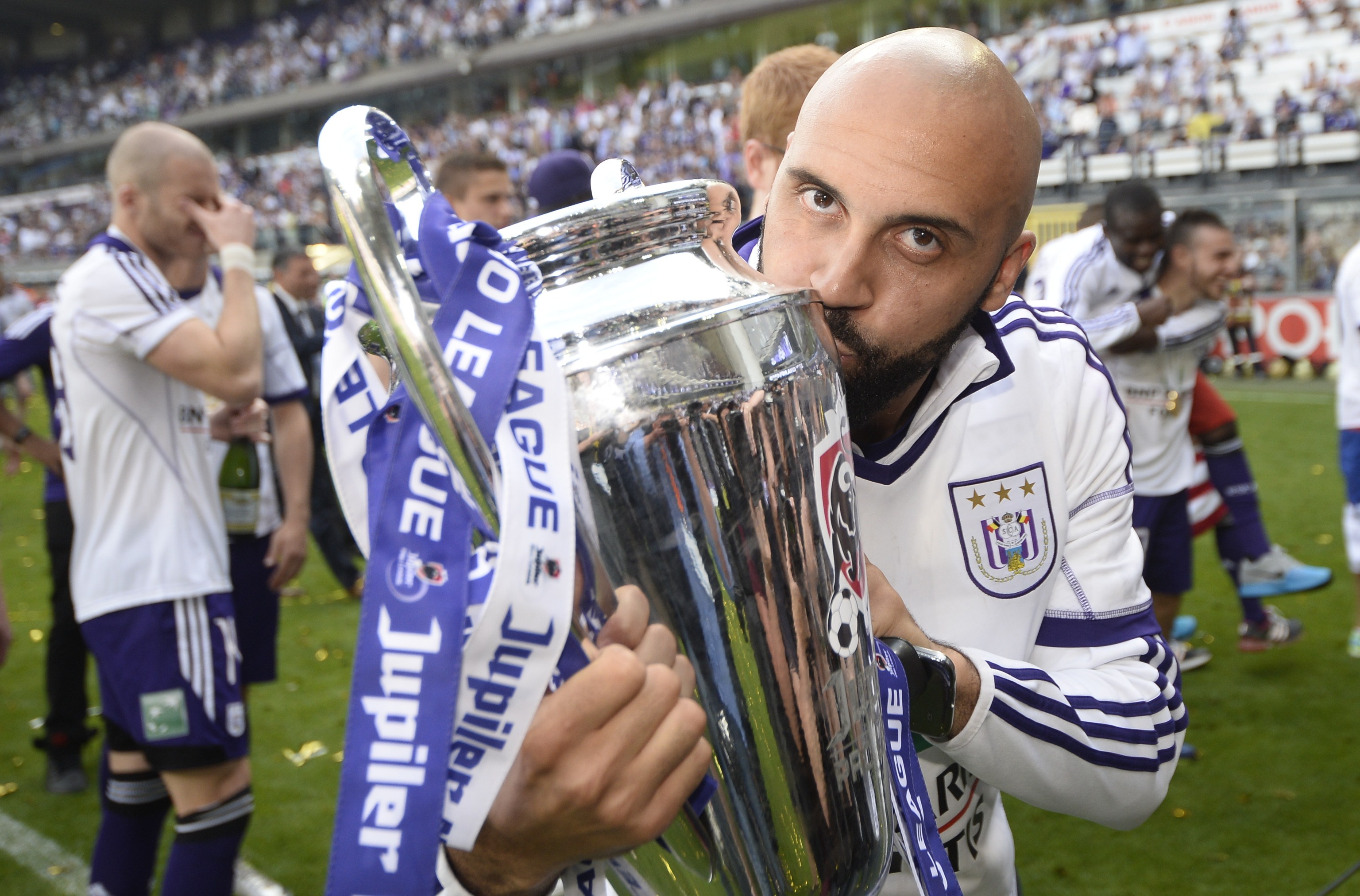 Anderlecht's Anthony Vanden Borre kisses the cup as he celebrates with teammates winning the Belgian championship Jupiler Pro League for the third consecutive time, at the end of the Play-Off final match against Sporting Lokeren on May 18, 2014 in Brussels. AFP PHOTO / BELGA PHOTO / DIRK WAEM ***Belgium Out*** (Photo credit should read DIRK WAEM/AFP/Getty Images)