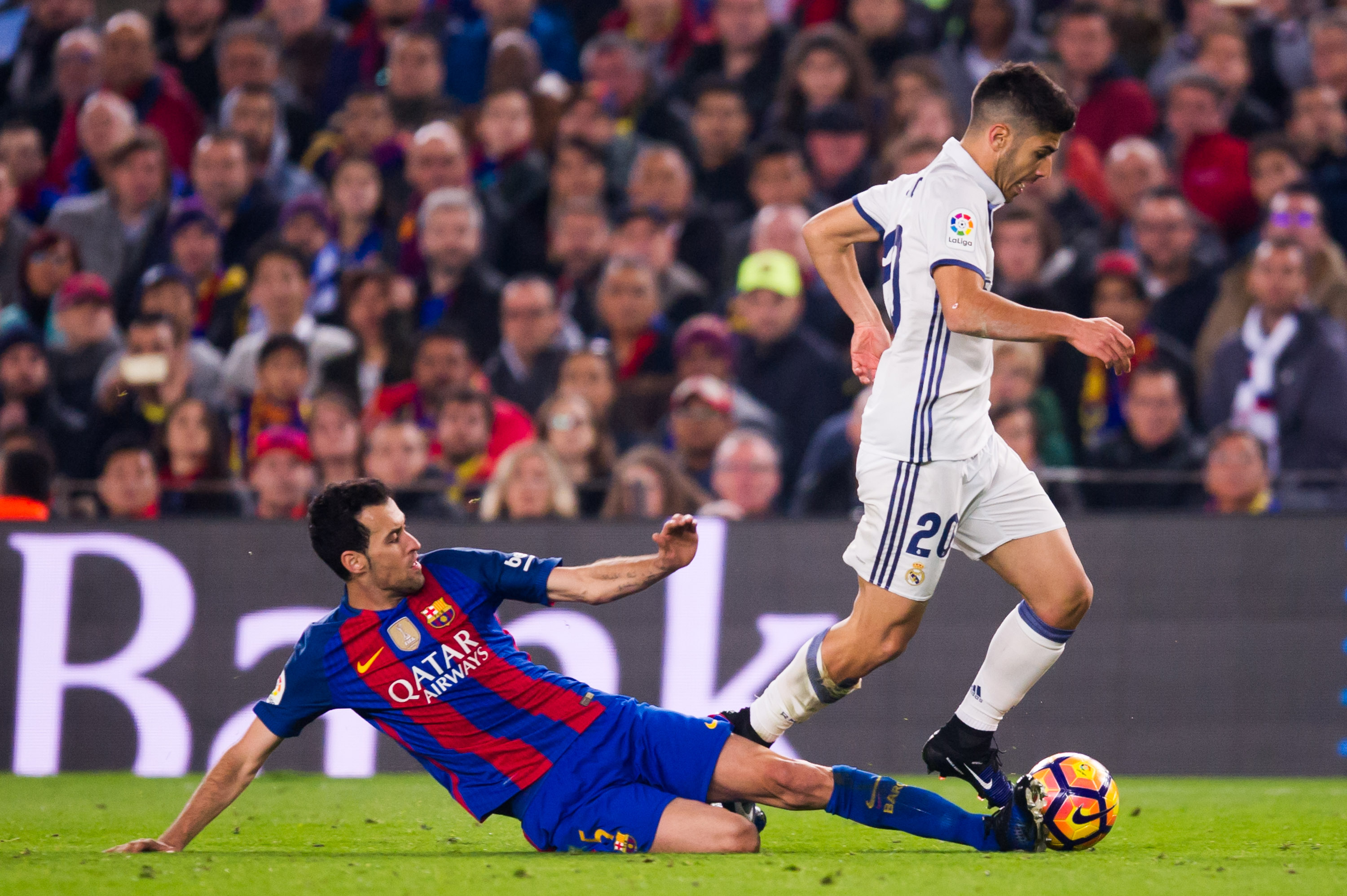 BARCELONA, SPAIN - DECEMBER 03: Sergio Busquets (L) of FC Barcelona tackles Marco Asensio of Real Madrid CF during the La Liga match between FC Barcelona and Real Madrid CF at Camp Nou stadium on December 3, 2016 in Barcelona, Spain. (Photo by Alex Caparros/Getty Images)