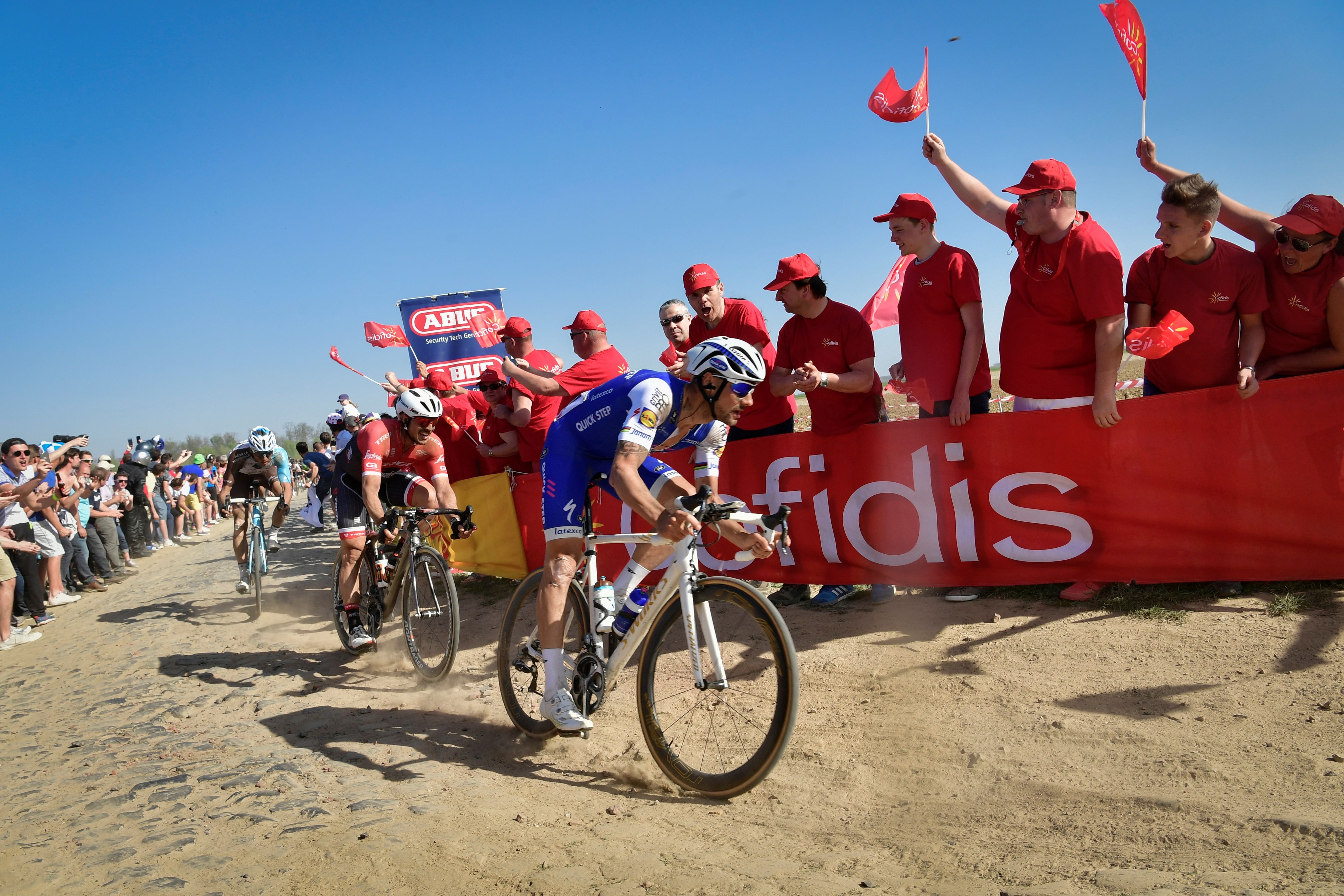 Belgium's Tom Boonen (R) rides on the cobblestones past supporters during the 115th edition of the Paris-Roubaix one-day classic cycling race, between Compiegne and Roubaix, on April 9, 2017. / AFP PHOTO / Philippe LOPEZ (Photo credit should read PHILIPPE LOPEZ/AFP/Getty Images)