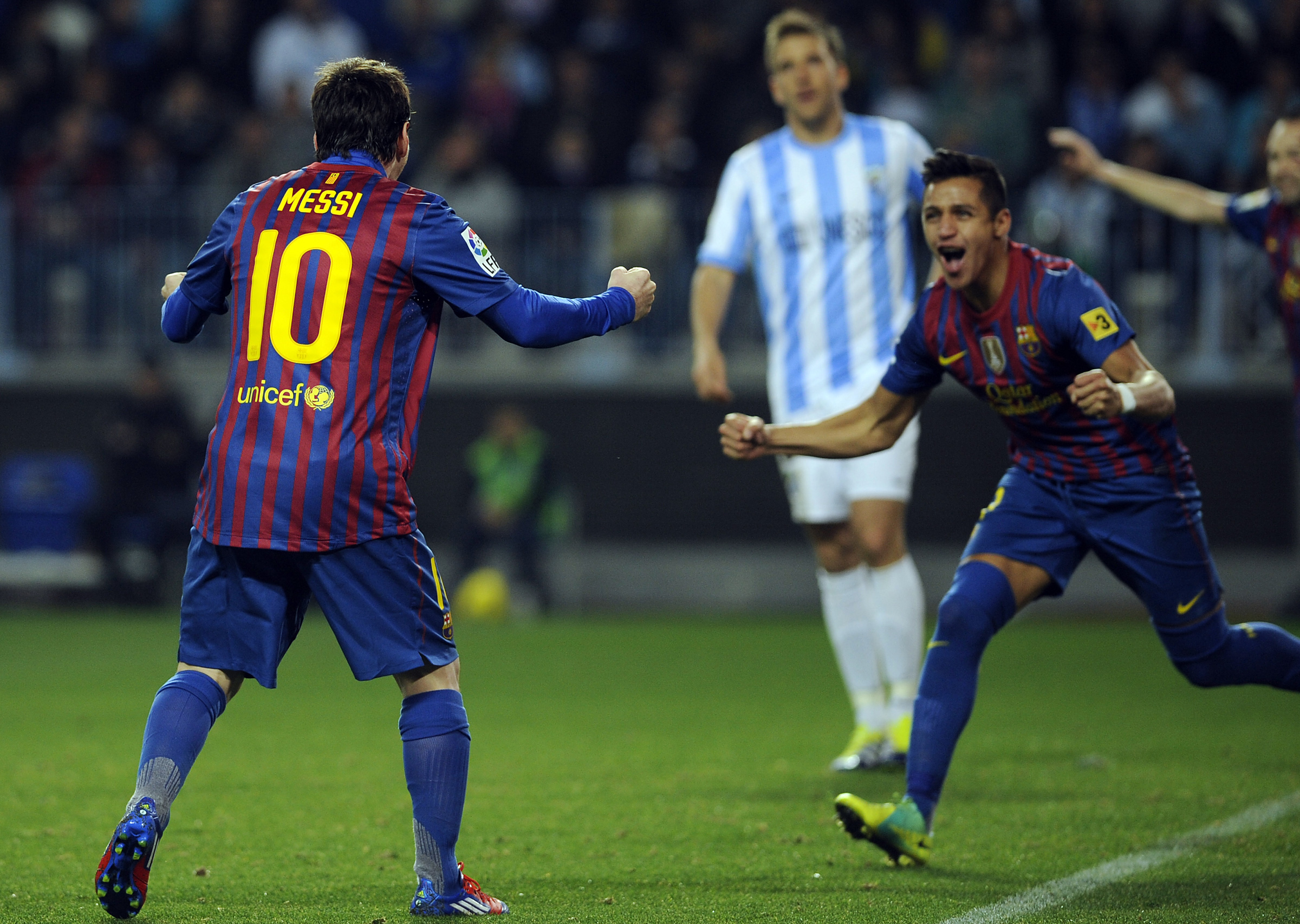 Barcelona's Chiliean forward Alexis Sanchez (R) celebrates with Barcelona's Argentinian forward Lionel Messi (L) after scoring against Malaga during their Spanish League football match, on January 22, 2012 at La Rosaleda stadium in Malaga. Barcelona won 1-4.AFP PHOTO / CRISTINA QUICLER (Photo credit should read CRISTINA QUICLER/AFP/Getty Images)