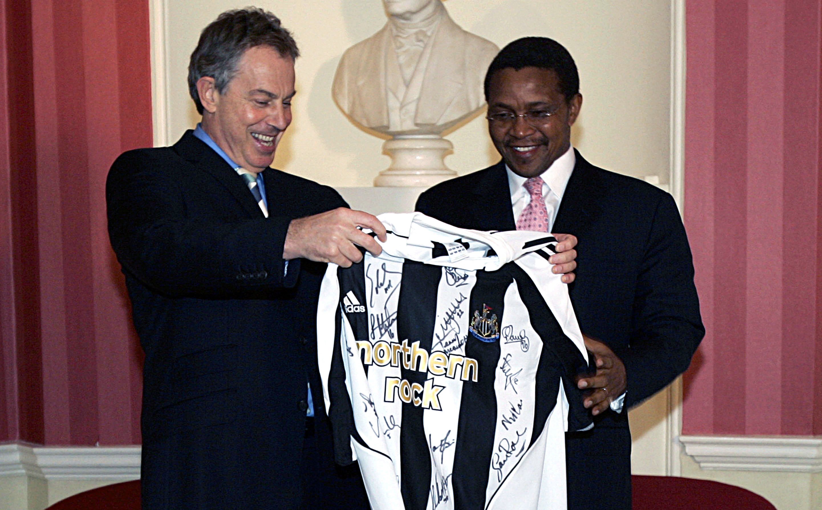 LONDON - JANUARY 16: Britain's Prime Minister Tony Blair (L) hands over a signed Newcastle United team shirt to the President of Tanzania, Jakaya Mrisho Kikwete as they meet inside 10 Downing Street on January 16, 2007 in London. Kikwete and Blair are both supporters of the English Premiership team based in northern England. (Photo by Alastair Grant-Pool/Getty Images)