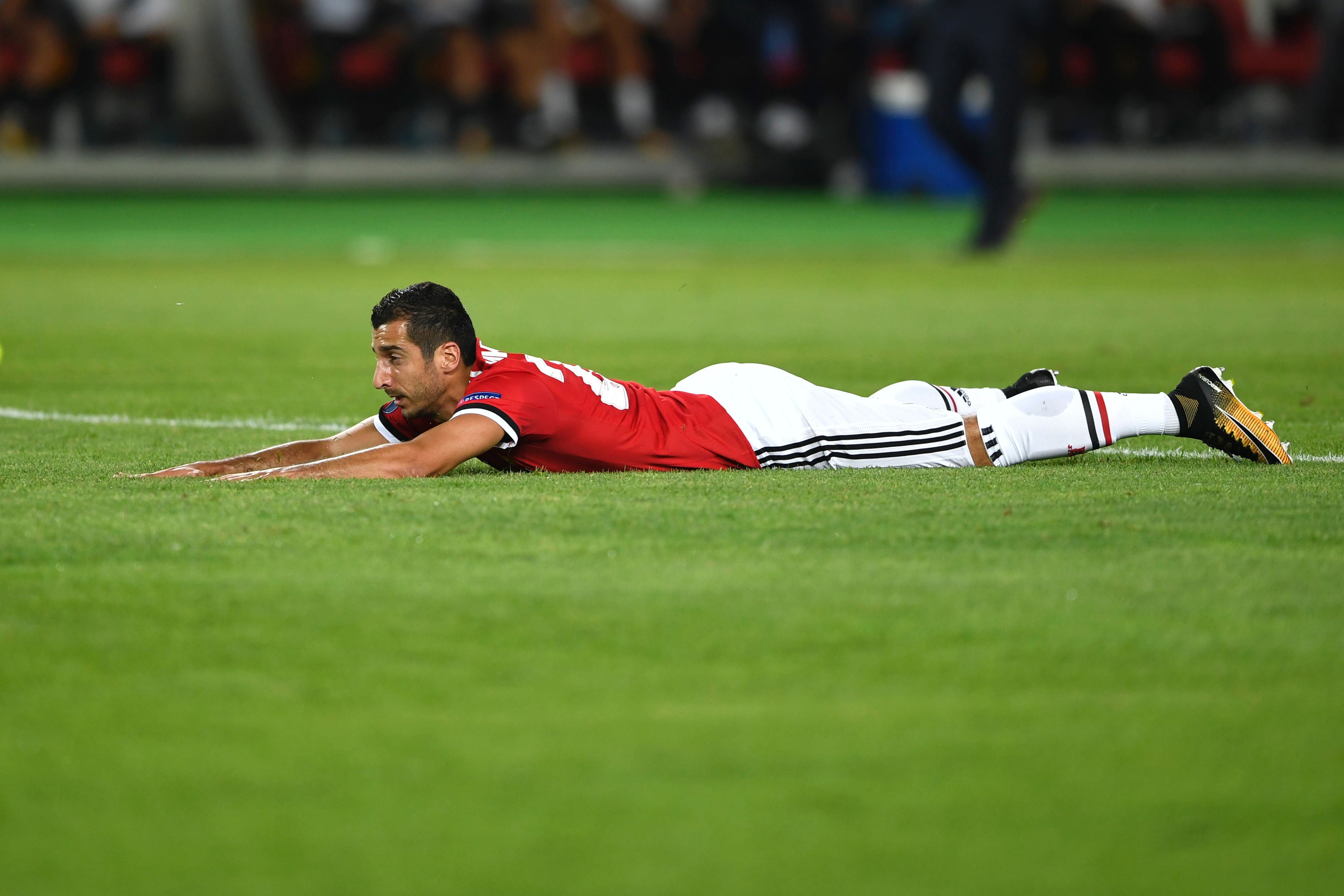 Manchester United's Armenian midfielder Henrikh Mkhitaryan lies on the lawn during the UEFA Super Cup football match between Real Madrid and Manchester United on August 8, 2017, at the Philip II Arena in Skopje. / AFP PHOTO / Dimitar DILKOFF (Photo credit should read DIMITAR DILKOFF/AFP/Getty Images)