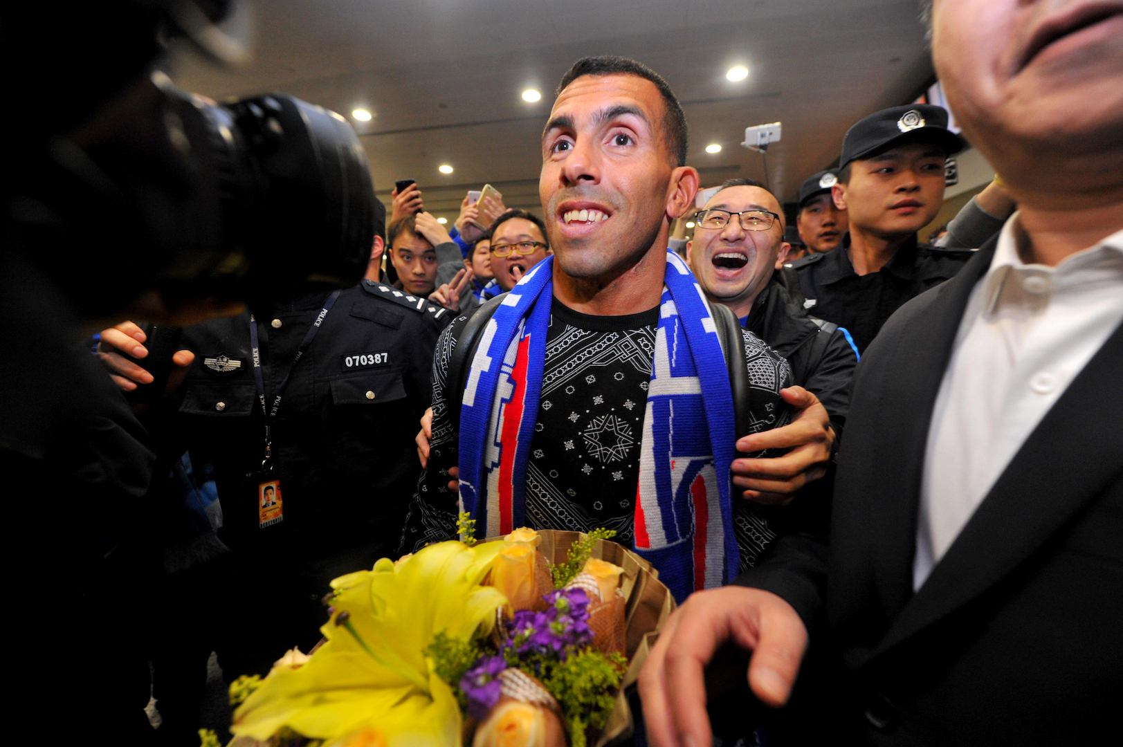 Argentine striker Carlos Tevez makes his way through the arrivals halls at Shanghai Pudong International Airport in Shanghai on January 19, 2017.  Tevez arrived to a rousing welcome from hundreds of fans in Shanghai, where he will join local side Shenhua in a deal that reportedly makes him the world's top-earning footballer. / AFP / STR / China OUT        (Photo credit should read STR/AFP/Getty Images)